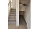 Carpeted staircase with open storage featuring shelving and lighting for convenience at 4613 W Fawn Dr, Laveen, AZ 85339