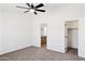 Spacious bedroom with a ceiling fan and views into the bathroom and walk-in closet at 51210 W Bluejay St, Maricopa, AZ 85139