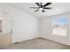 Comfortable bedroom features a ceiling fan, plush carpeting, and a window with natural light at 51210 W Bluejay St, Maricopa, AZ 85139