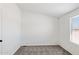 Bedroom with neutral carpet, a large window, and a modern ceiling light fixture at 51210 W Bluejay St, Maricopa, AZ 85139