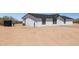 Side exterior featuring white siding, dark trim, and water tank at 51210 W Bluejay St, Maricopa, AZ 85139