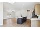 Bright living area with laminate flooring, white walls, and a kitchen island for a modern, open feel at 51210 W Bluejay St, Maricopa, AZ 85139