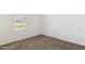 A bright bedroom with neutral walls, carpeted flooring, and a window with blinds at 51288 W Bluejay St, Maricopa, AZ 85139