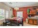 Dining area featuring wood table with red tablecloth, laminate floor and a kitchen view at 5342 W Maldonado Rd, Laveen, AZ 85339