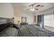 This bedroom features a ceiling fan, a large window, and a black accent wall at 5342 W Maldonado Rd, Laveen, AZ 85339