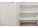 Walk-in closet with white shelving and light wood-look flooring at 5537 S 246Th Ave, Buckeye, AZ 85326