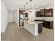 Open-concept kitchen with an island, stainless steel appliances, and dark wood cabinetry at 5537 S 246Th Ave, Buckeye, AZ 85326