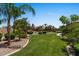 Green backyard with palm trees, shrubbery and a winding path at 5755 S Pearl Dr, Chandler, AZ 85249