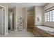 Relaxing bathroom featuring tiled shower, soaker tub, and natural stone accents at 5755 S Pearl Dr, Chandler, AZ 85249