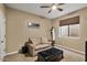 Bedroom with a ceiling fan, couch, leather ottoman and window for natural light at 5755 S Pearl Dr, Chandler, AZ 85249