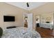 Comfortable bedroom featuring a ceiling fan, a large mirror and a flatscreen television at 5755 S Pearl Dr, Chandler, AZ 85249