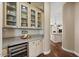 Butler's pantry with granite countertops and glass-front cabinets for storing dishware at 5755 S Pearl Dr, Chandler, AZ 85249