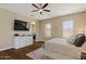 Comfortable bedroom featuring wood floors and a large TV with bright natural lighting at 5755 S Pearl Dr, Chandler, AZ 85249