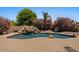 Beautiful pool with a rock waterfall feature and lush landscaping at 5755 S Pearl Dr, Chandler, AZ 85249