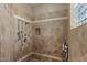 Walk-in shower with stone tile, multiple shower heads, and corner shelving at 5755 S Pearl Dr, Chandler, AZ 85249