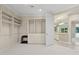 Spacious walk-in closet with custom built-in shelving and drawers, and neutral carpet at 6467 E Sierra Vista Dr, Paradise Valley, AZ 85253