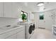 Bright laundry room with white cabinets, modern washer and dryer, and a sink at 6467 E Sierra Vista Dr, Paradise Valley, AZ 85253