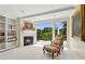 Bright living room with a fireplace, shelving, and access to a balcony with scenic views at 6467 E Sierra Vista Dr, Paradise Valley, AZ 85253