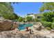 Backyard pool oasis with lush landscaping, rock features, and a relaxing lounge area at 6467 E Sierra Vista Dr, Paradise Valley, AZ 85253