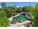 Inviting backyard with a freeform pool, rock waterfall, lush greenery, and sunbathing area at 6467 E Sierra Vista Dr, Paradise Valley, AZ 85253
