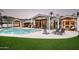 Inviting backyard oasis with a sparkling pool, lush lawn, and comfortable lounge seating for relaxation at 7100 N 47Th St, Paradise Valley, AZ 85253