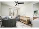 Bright bedroom featuring a crib, bed, comfortable chair, ceiling fan and neutral décor at 7100 N 47Th St, Paradise Valley, AZ 85253