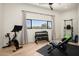 Home gym area equipped with workout equipment, including a stationary bike, weights, and a bench at 7100 N 47Th St, Paradise Valley, AZ 85253