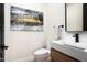 Modern powder room features floating vanity, rectangular mirror, and stylish abstract art at 7100 N 47Th St, Paradise Valley, AZ 85253