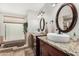 Bathroom featuring separate sinks with granite countertops, framed mirrors, and a jetted soaking tub at 7354 E San Miguel Ave, Scottsdale, AZ 85250