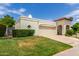 Inviting single-story home featuring a two-car garage, tile roof accents, and vibrant green lawn with mature landscaping at 7354 E San Miguel Ave, Scottsdale, AZ 85250