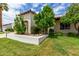 Landscaped front yard featuring lush green lawn, mature trees, and a charming stucco wall, enhancing the property's curb appeal at 7354 E San Miguel Ave, Scottsdale, AZ 85250