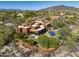 Stunning aerial view of a uniquely designed home with a pool, surrounded by desert landscape and mountain views at 7547 E Mary Sharon Dr, Scottsdale, AZ 85266