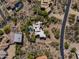 Aerial view of a desert home with a pool and surrounding desert landscape and greenery at 7547 E Mary Sharon Dr, Scottsdale, AZ 85266