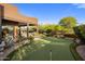 Lush backyard featuring a putting green, mature trees, and manicured landscaping, enhancing the home's serene outdoor appeal at 7547 E Mary Sharon Dr, Scottsdale, AZ 85266
