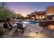 Beautiful backyard featuring a pool, lounge chairs, outdoor grill and fireplace, set against a backdrop of a Southwestern home at 7547 E Mary Sharon Dr, Scottsdale, AZ 85266