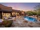 Inviting backyard pool and patio area with lush landscaping, comfortable seating, and a built-in outdoor kitchen at 7547 E Mary Sharon Dr, Scottsdale, AZ 85266