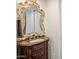 Bathroom featuring an ornate mirror, marble vanity, and vintage-style fixtures at 7547 E Mary Sharon Dr, Scottsdale, AZ 85266
