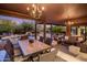 Inviting covered patio featuring an outdoor dining area and lounge space with a view of the pool and landscaped backyard at 7547 E Mary Sharon Dr, Scottsdale, AZ 85266