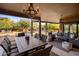Inviting covered patio featuring an outdoor dining area and lounge space with a view of the pool and landscaped backyard at 7547 E Mary Sharon Dr, Scottsdale, AZ 85266