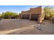 Attached two-car garage with wooden doors, complimented by a brick-paved driveway and desert landscaping at 7547 E Mary Sharon Dr, Scottsdale, AZ 85266