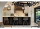 Modern kitchen with granite countertops, stylish pendant lights, stainless steel appliances and barstool seating at the island at 7547 E Mary Sharon Dr, Scottsdale, AZ 85266