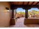 Covered porch with wooden beams, terracotta tiling, and views of the desert landscape at 7547 E Mary Sharon Dr, Scottsdale, AZ 85266