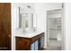 Modern bathroom featuring wood cabinet, dual sinks, and a large walk-in closet at 7646 E Catalina Dr, Scottsdale, AZ 85251