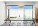 Sunlit dining area featuring a wooden table, clear chairs and a large window at 7646 E Catalina Dr, Scottsdale, AZ 85251