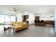 Modern living room featuring a yellow sofa, dining area, kitchen island, and sleek gray flooring at 7646 E Catalina Dr, Scottsdale, AZ 85251