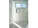 Modern shower featuring white square tile, blue trim, glass partition and terrazzo flooring at 7646 E Catalina Dr, Scottsdale, AZ 85251