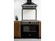 Close-up of the kitchen stove with a black range hood and stylish tile backsplash at 7646 E Catalina Dr, Scottsdale, AZ 85251