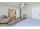 Bedroom with a bed, patterned chair, ceiling fan, and ensuite bath at 7684 E Minnezona Ave, Scottsdale, AZ 85251