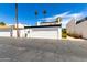 Garage exterior with desert landscaping, complemented by palm trees and a clear blue sky at 7684 E Minnezona Ave, Scottsdale, AZ 85251