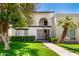 Charming two-story condo featuring a gated entry, balcony, and lush desert landscaping at 7684 E Minnezona Ave, Scottsdale, AZ 85251